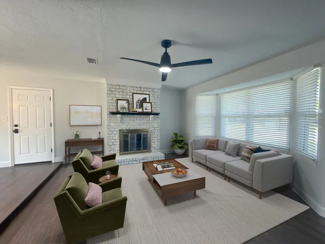 a living room with furniture a fireplace and a large window