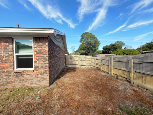 front view of a house with a yard and a large tree