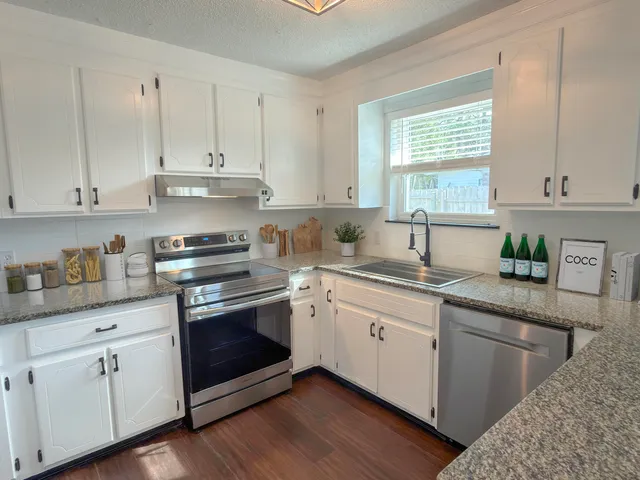 a kitchen with granite countertop white cabinets and white appliances