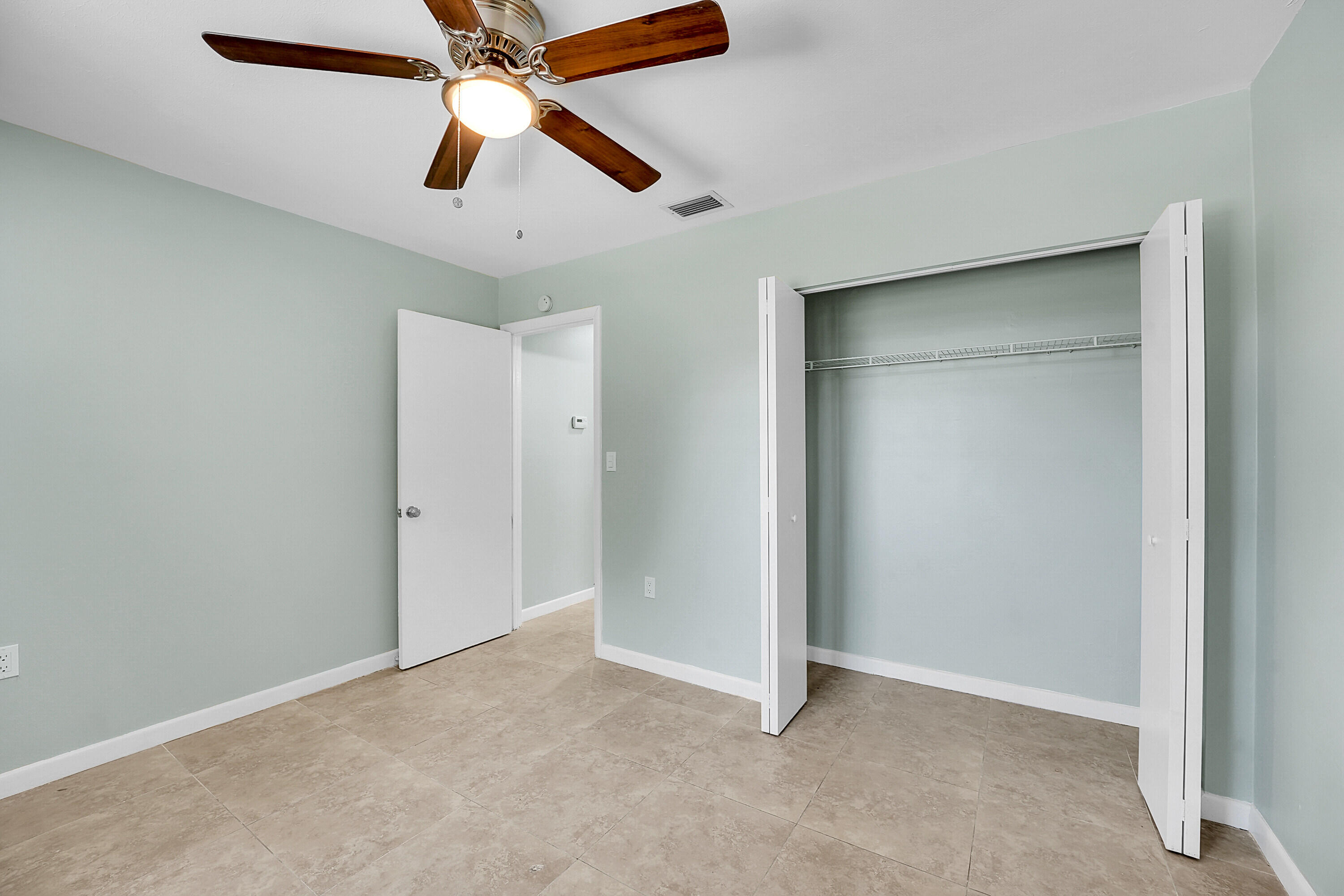 302 West Arbor Avenue Port St. Lucie, FL 34952 - Photo 14 of 25 an empty room with closet and a chandelier fan
