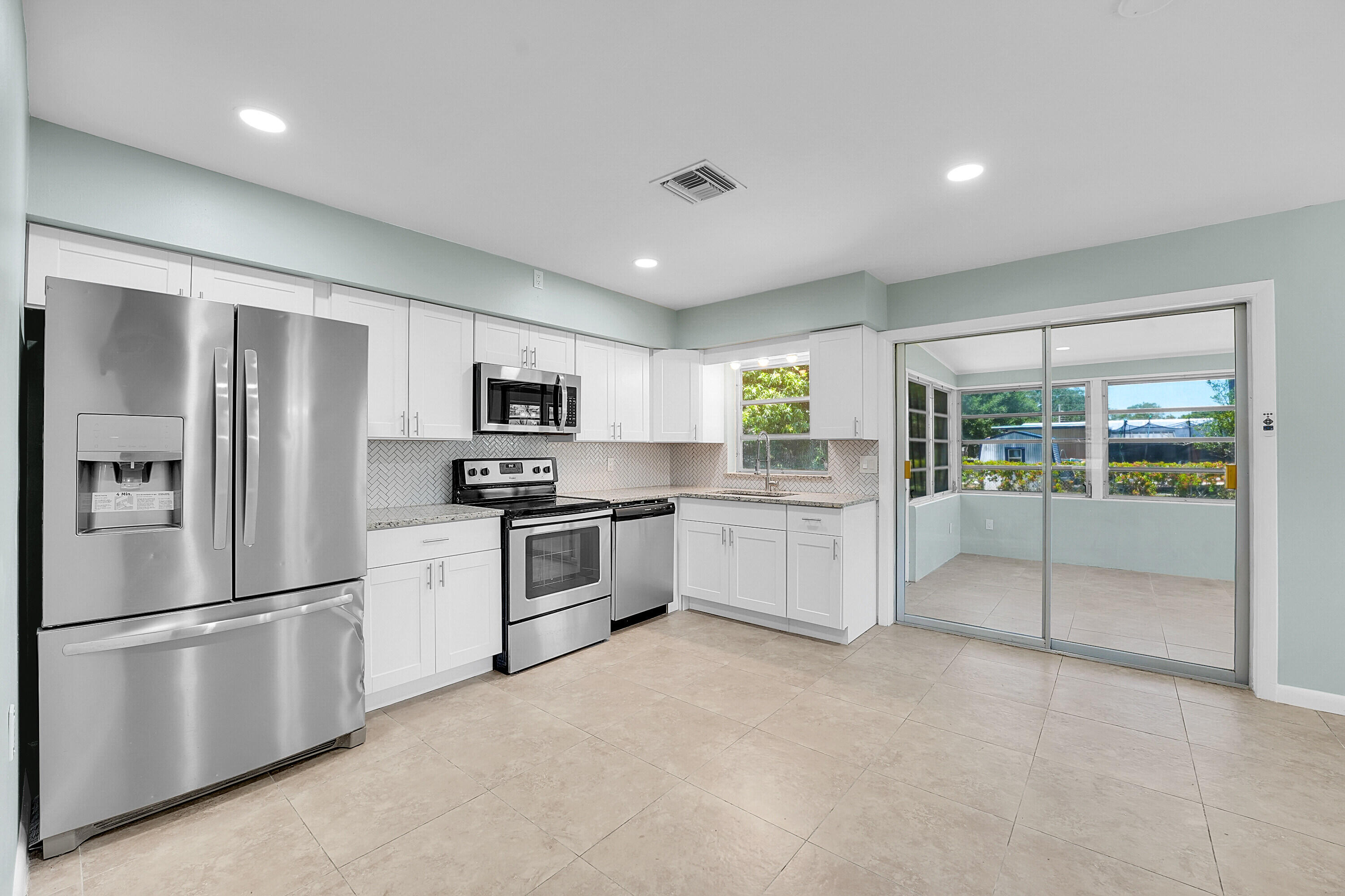 302 West Arbor Avenue Port St. Lucie, FL 34952 - Photo 8 of 25 a kitchen with stainless steel appliances a refrigerator sink and stove