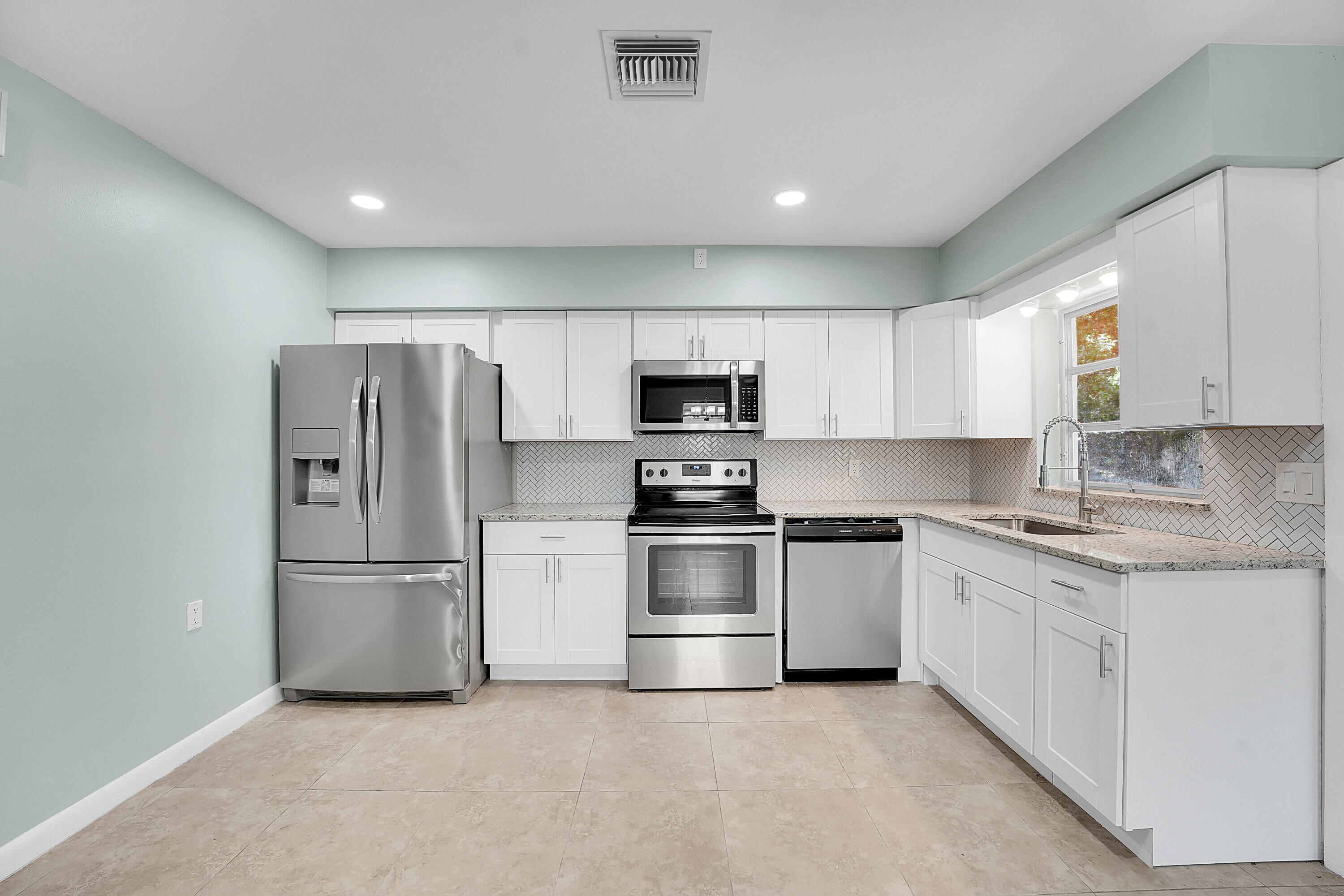 302 West Arbor Avenue Port St. Lucie, FL 34952 - Photo 9 of 25 a kitchen with stainless steel appliances granite countertop a refrigerator and a stove top oven