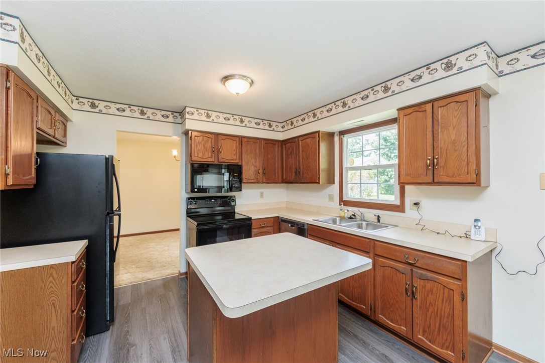 3324 Marsh Road Stow, OH 44224 - Photo 12 of 33 Kitchen with black appliances, brown cabinetry, dark wood-style flooring, and light countertops