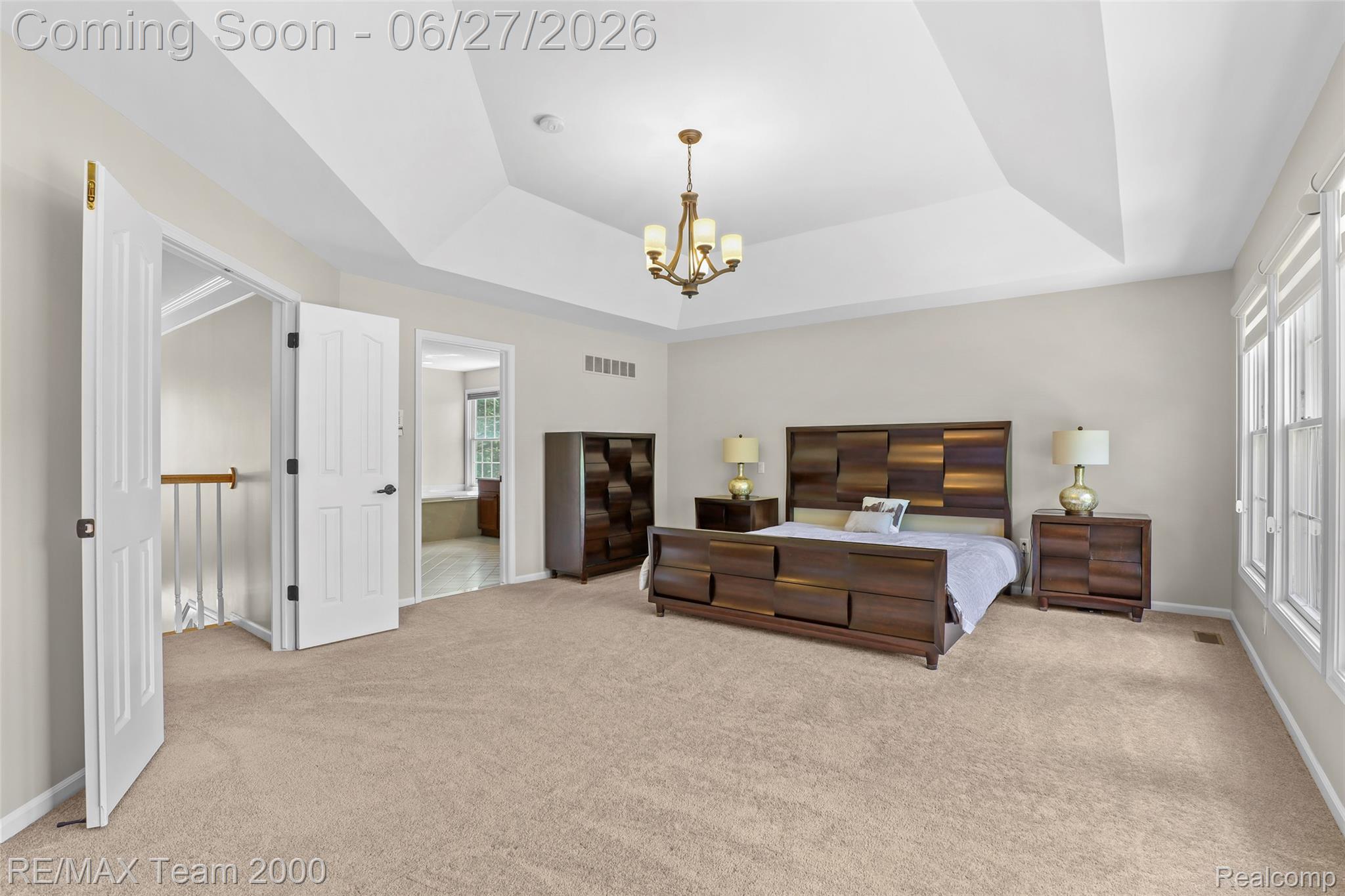 1248 Lasalle Road Canton, MI 48187 - Photo 53 of 67 Spacious room featuring a tray ceiling, ceiling-mounted chandelier, beige carpet flooring, multiple windows providing natural light, and two white panel doors