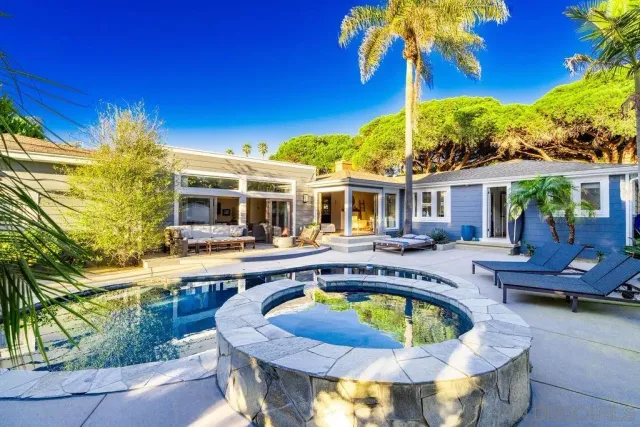 a view of a house with pool and chairs