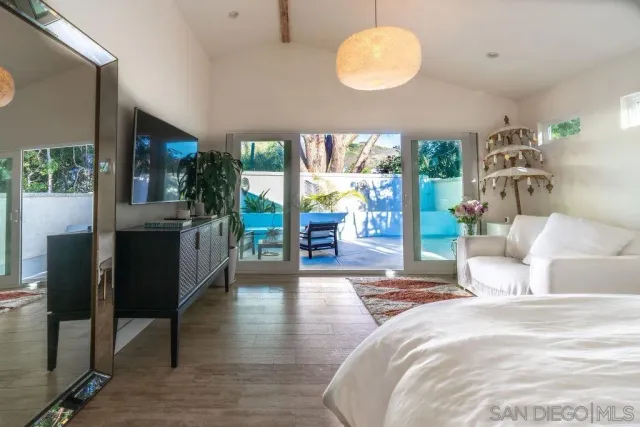 a bedroom with a large bed and a wooden floor