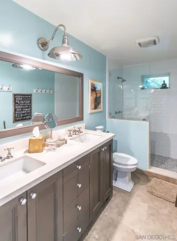 a bathroom with a sink mirror toilet and shower