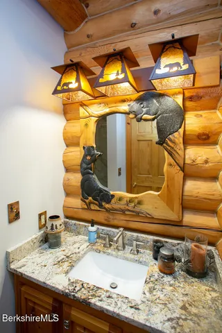 a bathroom with a granite countertop sink and a mirror