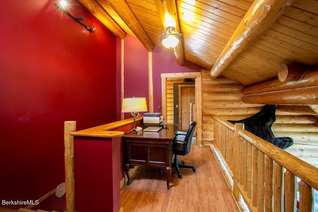a view of a room with chairs and wooden floor