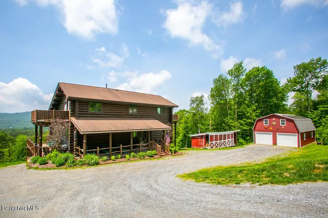 a front view of house with yard and trees in the background