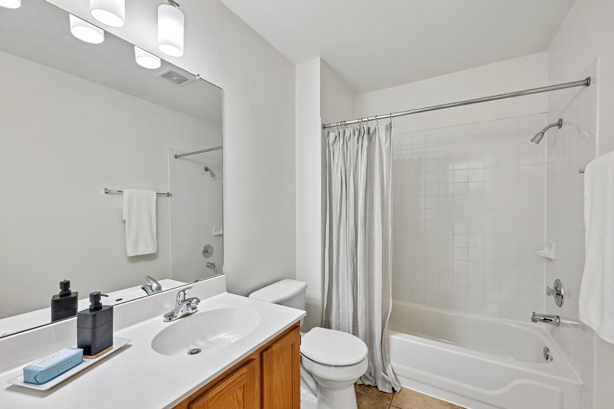 4100 Mocha Trail Austin, TX 78728 - Photo 18 of 33 A well-lit, functional bathroom with a tub-shower combination and a clean vanity.