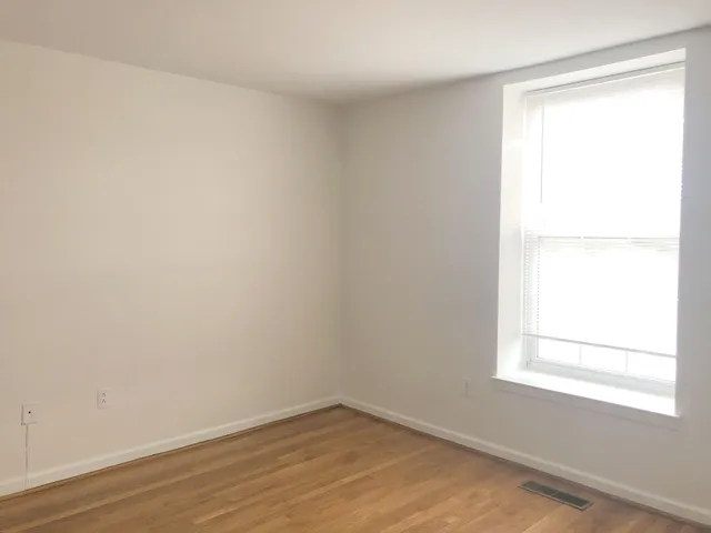 a view of a small space with wooden floor and a window