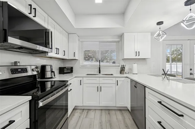 a kitchen with stainless steel appliances a refrigerator sink and microwave