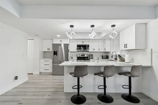 a kitchen with kitchen island white cabinets and stainless steel appliances