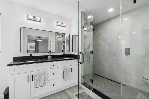 a bathroom with a granite countertop sink a toilet and mirror