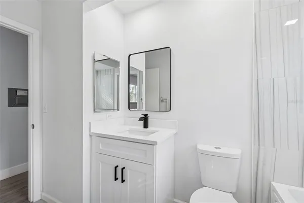 a view of a room with wooden floor and ceiling fan