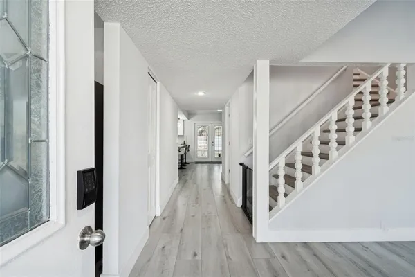 a view of a hallway with wooden floor and staircase
