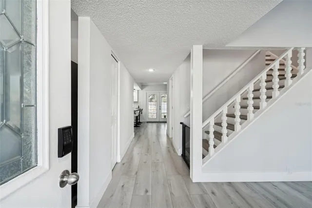 a view of a hallway with wooden floor and staircase