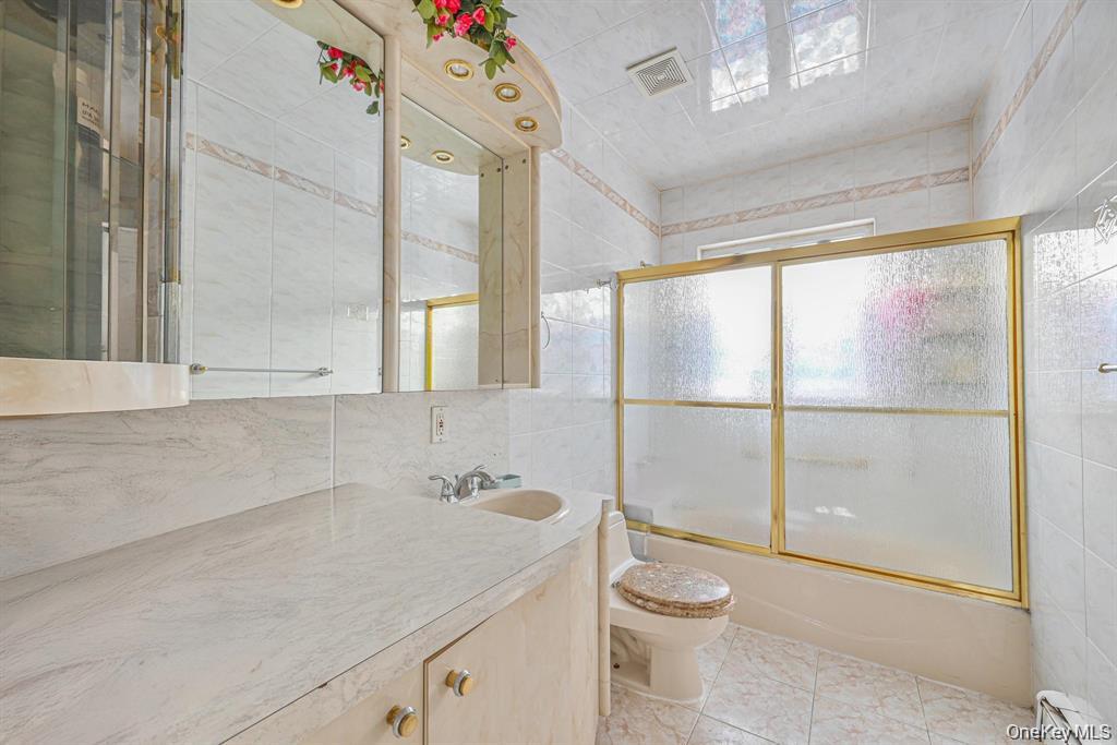 102-01 62nd Road Queens, NY 11375 - Photo 11 of 16 a bathroom with a granite countertop sink a toilet and a shower