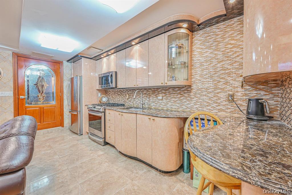 102-01 62nd Road Queens, NY 11375 - Photo 13 of 16 a kitchen with stainless steel appliances granite countertop a sink stove and granite countertops
