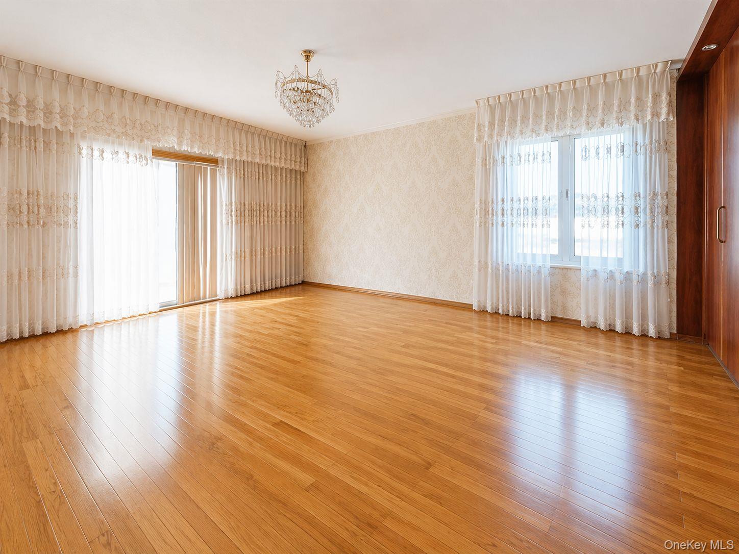 102-01 62nd Road Queens, NY 11375 - Photo 3 of 16 a view of an empty room with wooden floor and a window