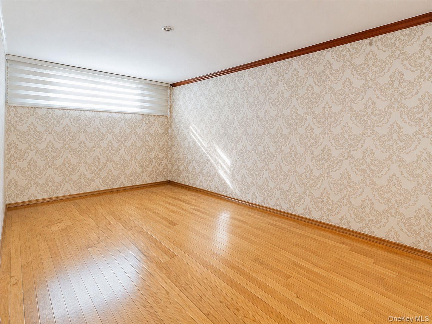 102-01 62nd Road Queens, NY 11375 - Photo 4 of 16 a view of an empty room with wooden floor and a window