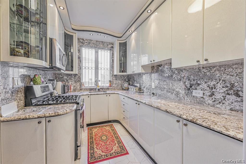 102-01 62nd Road Queens, NY 11375 - Photo 6 of 16 a kitchen with granite countertop a sink stove and cabinets