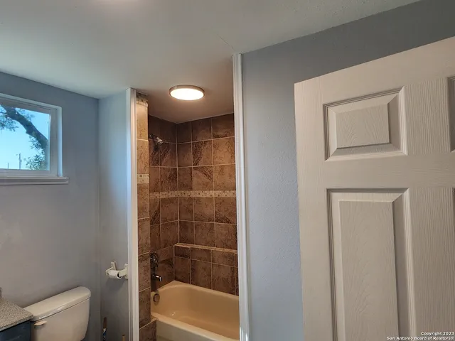 a bathroom with a shower a toilet and a sink