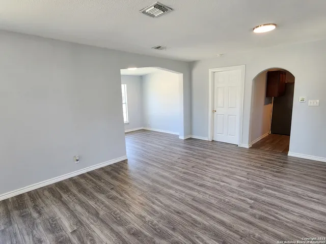 a view of an empty room with wooden floor