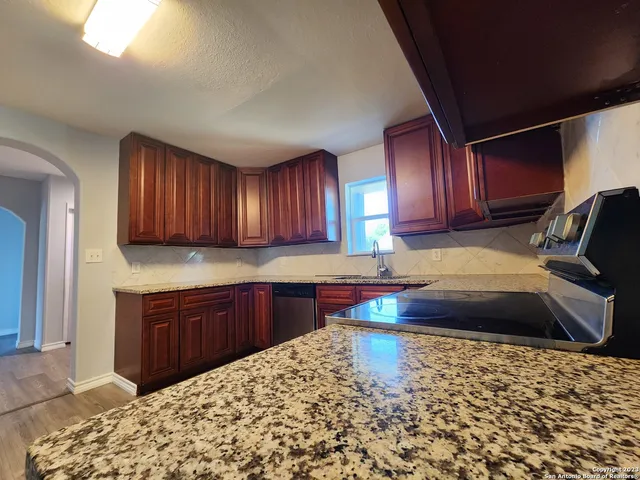 a kitchen with stainless steel appliances granite countertop a sink stove and cabinets