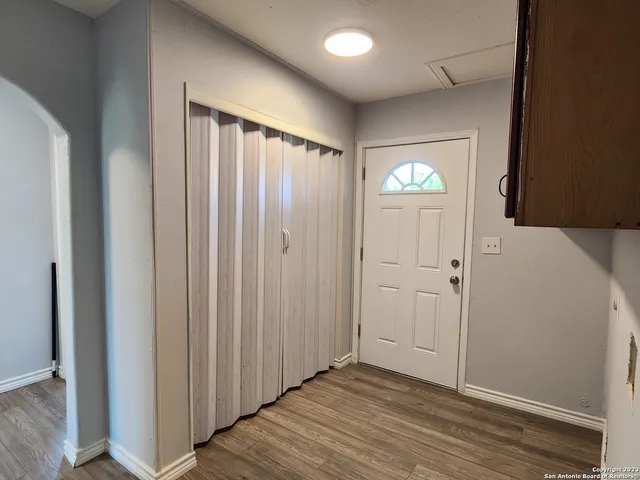 a view of an empty room with wooden floor