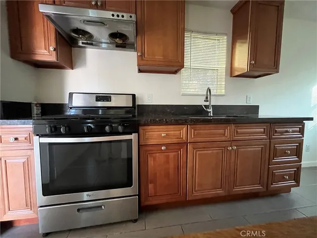 a kitchen with granite countertop a stove and a sink