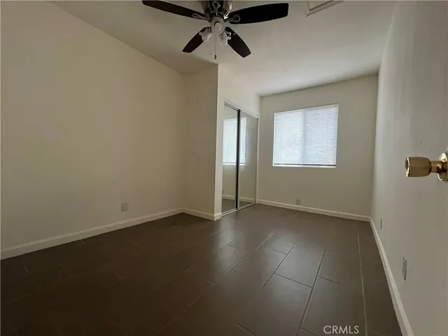 an empty room with windows and fan