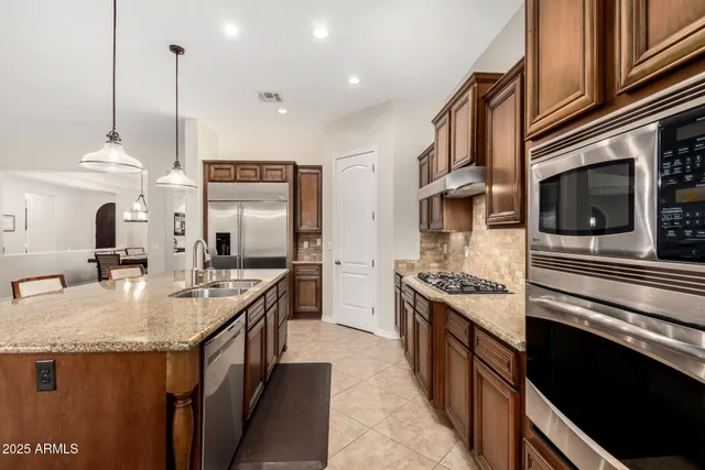 a kitchen with stainless steel appliances granite countertop a stove a sink and a microwave