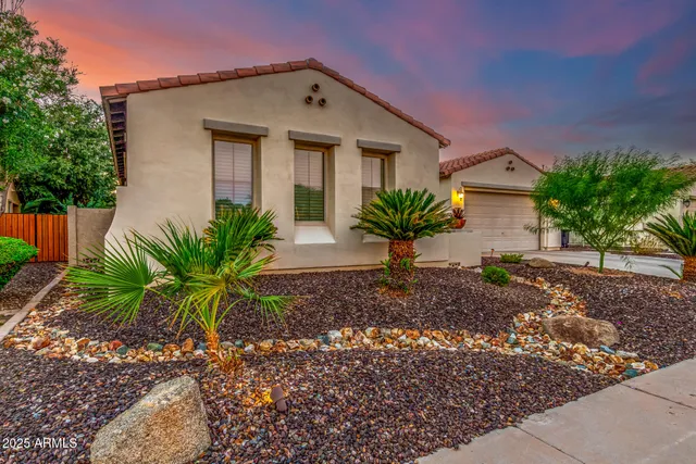 a large bed sitting in a bedroom next to a lamp and a chandelier