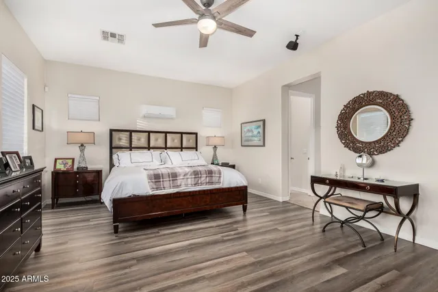 a bedroom with a bed couches and a flat tv screen