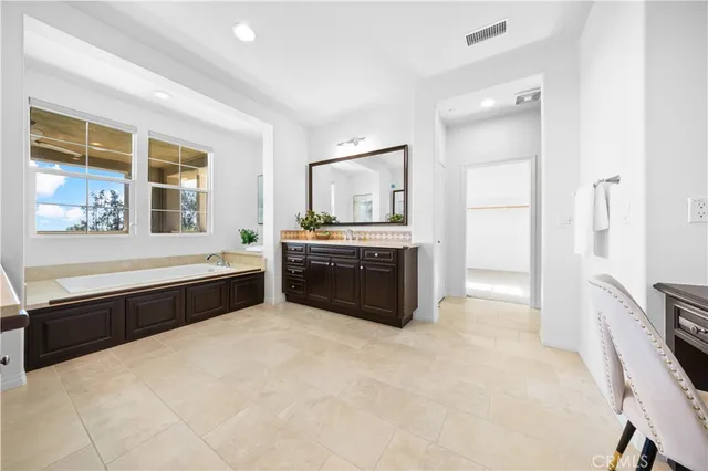 a large white kitchen with granite countertop a stove a sink and a refrigerator