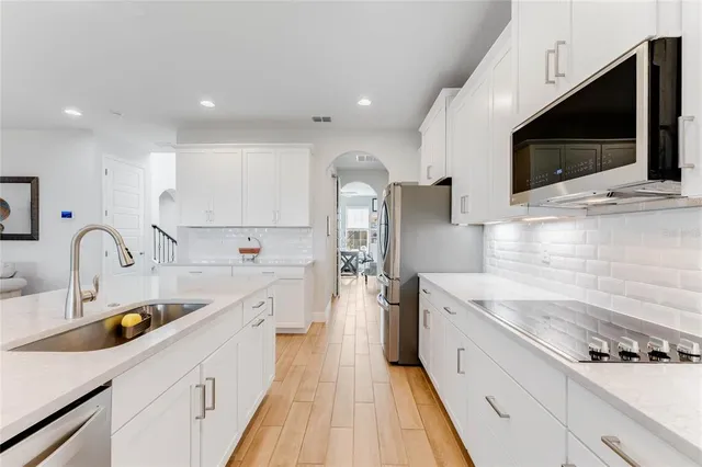 a large kitchen with stainless steel appliances kitchen island granite countertop a sink and cabinets