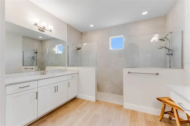 a bathroom with a granite countertop sink a mirror and a shower