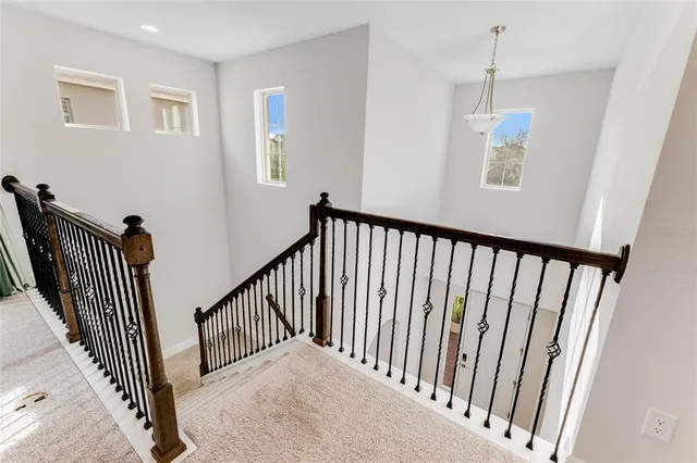 a view of a hallway with wooden floor and windows