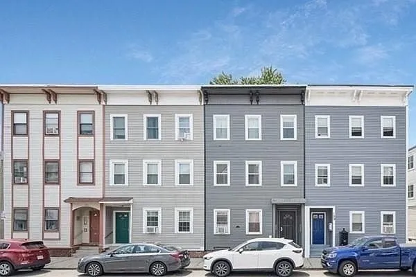 a front view of building with cars parked