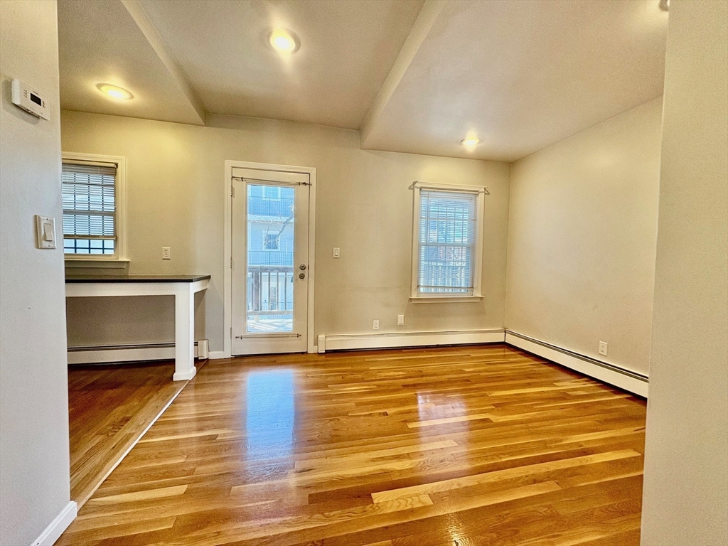 131 West Seventh Street, Unit 2 Boston, MA 02127 - Photo 6 of 11 a view of empty room with kitchen and windows