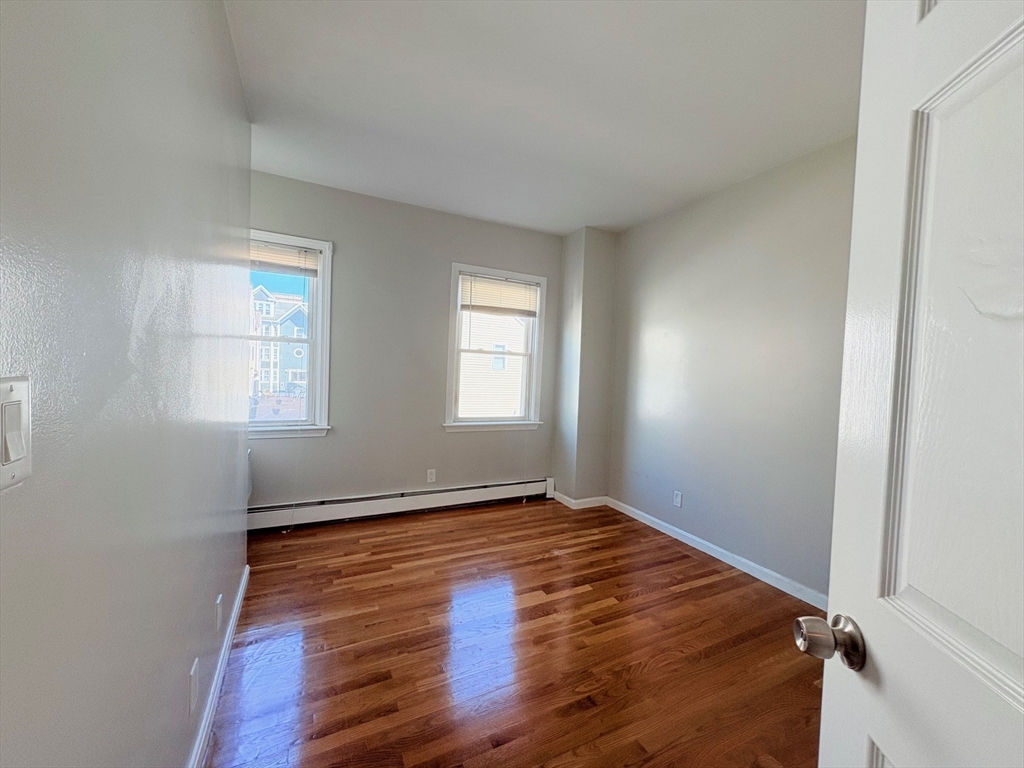 131 West Seventh Street, Unit 2 Boston, MA 02127 - Photo 10 of 11 an empty room with wooden floor and windows