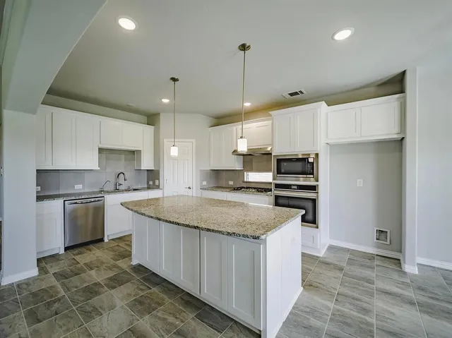 an empty room with chandelier and windows