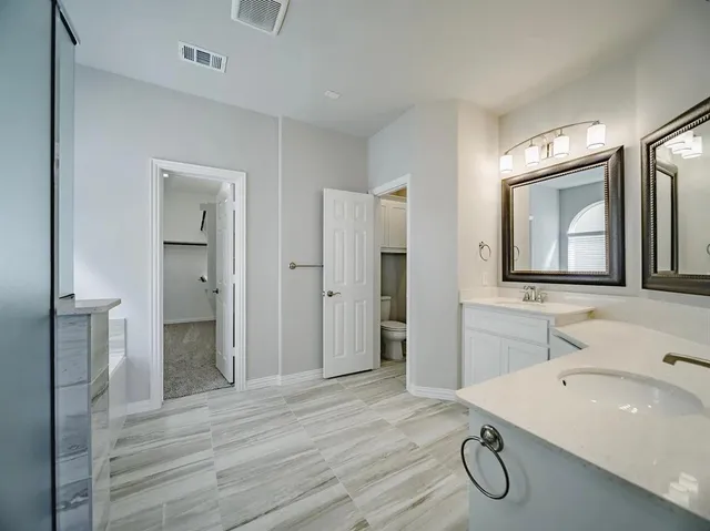 a bathroom with a double vanity sink and a mirror