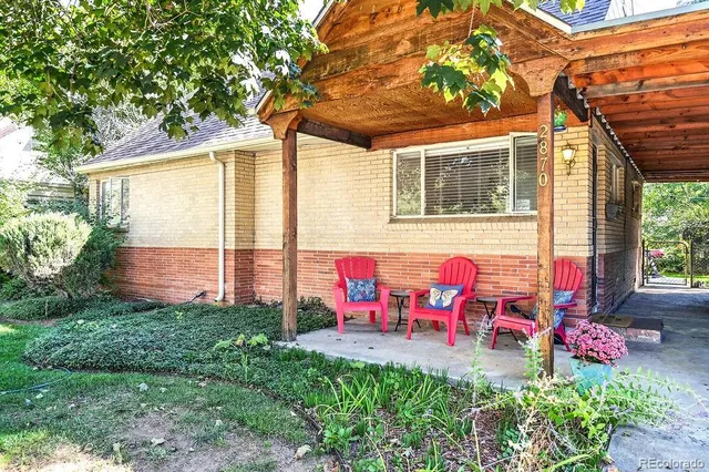 a view of a chairs and table in the back yard of the house