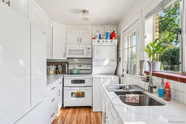 a kitchen with white cabinets and white appliances