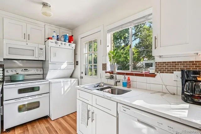 a kitchen with kitchen island white cabinets and white appliances