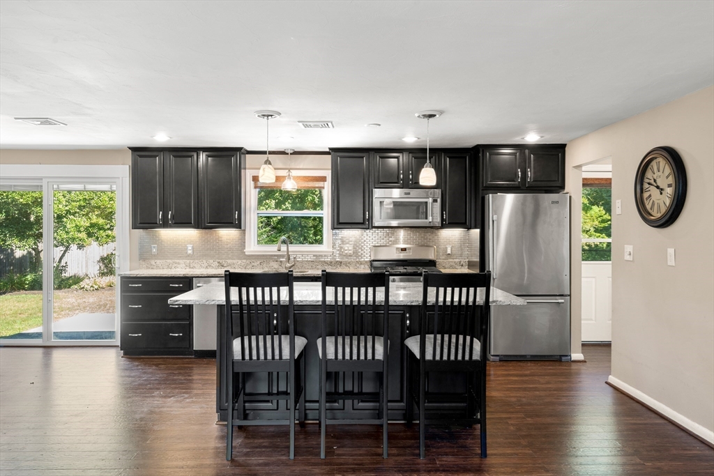 40 Randolph Street Canton, MA 02021 - Photo 4 of 35 a kitchen with stainless steel appliances granite countertop a refrigerator a stove a dining table and chairs with wooden floor