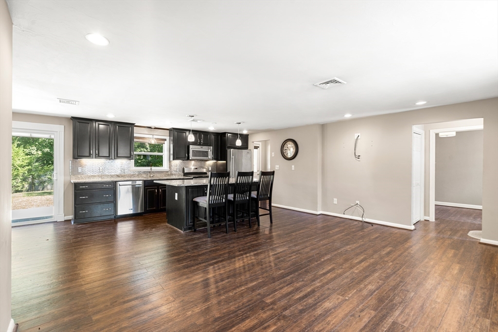 40 Randolph Street Canton, MA 02021 - Photo 9 of 35 a open kitchen with stainless steel appliances kitchen island granite countertop a table chairs and a sink